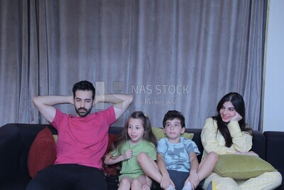 a family of four watching television