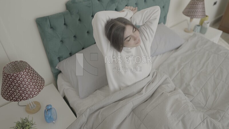a woman sitting in bed waking up