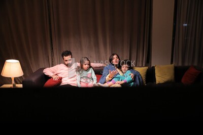 a family of four watching television