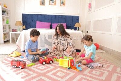 a woman sitting with her children playing