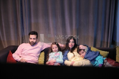 a family of four watching television