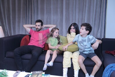 a family of four watching television