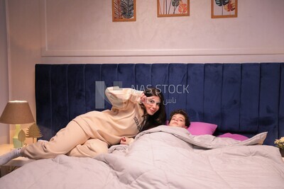 a mother sitting on the bed during his boy&#39;s sleep