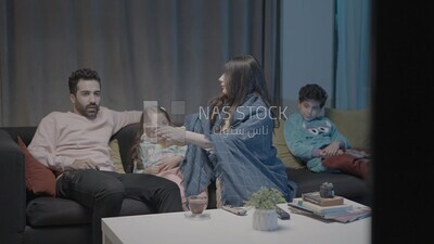 a family of four watching television