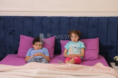 a brother and his sister lying in bed