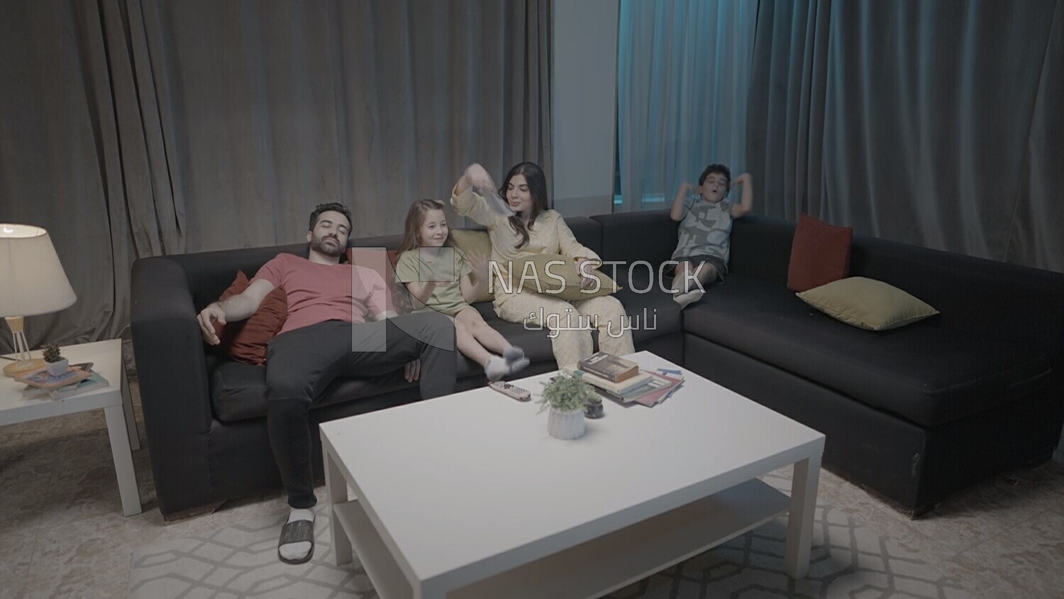 a family of four watching television