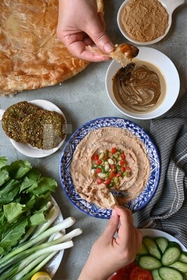 Hands eating egyptian feteer meshaltet