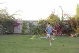 a boy playing football in the garden