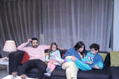 a family of four watching television