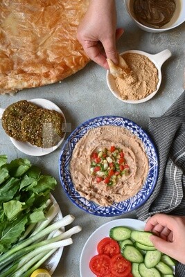 Hands eating egyptian feteer meshaltet