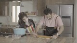 a man and a woman standing and cooking in the kitchen