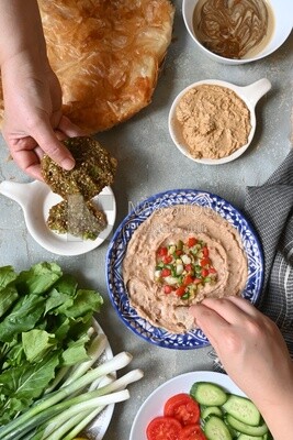 Hands eating egyptian feteer meshaltet