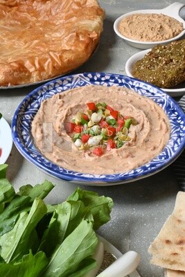 طبق فول بالطحينة مع خضروات عليها