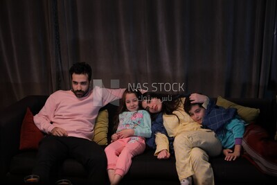 a family of four watching television