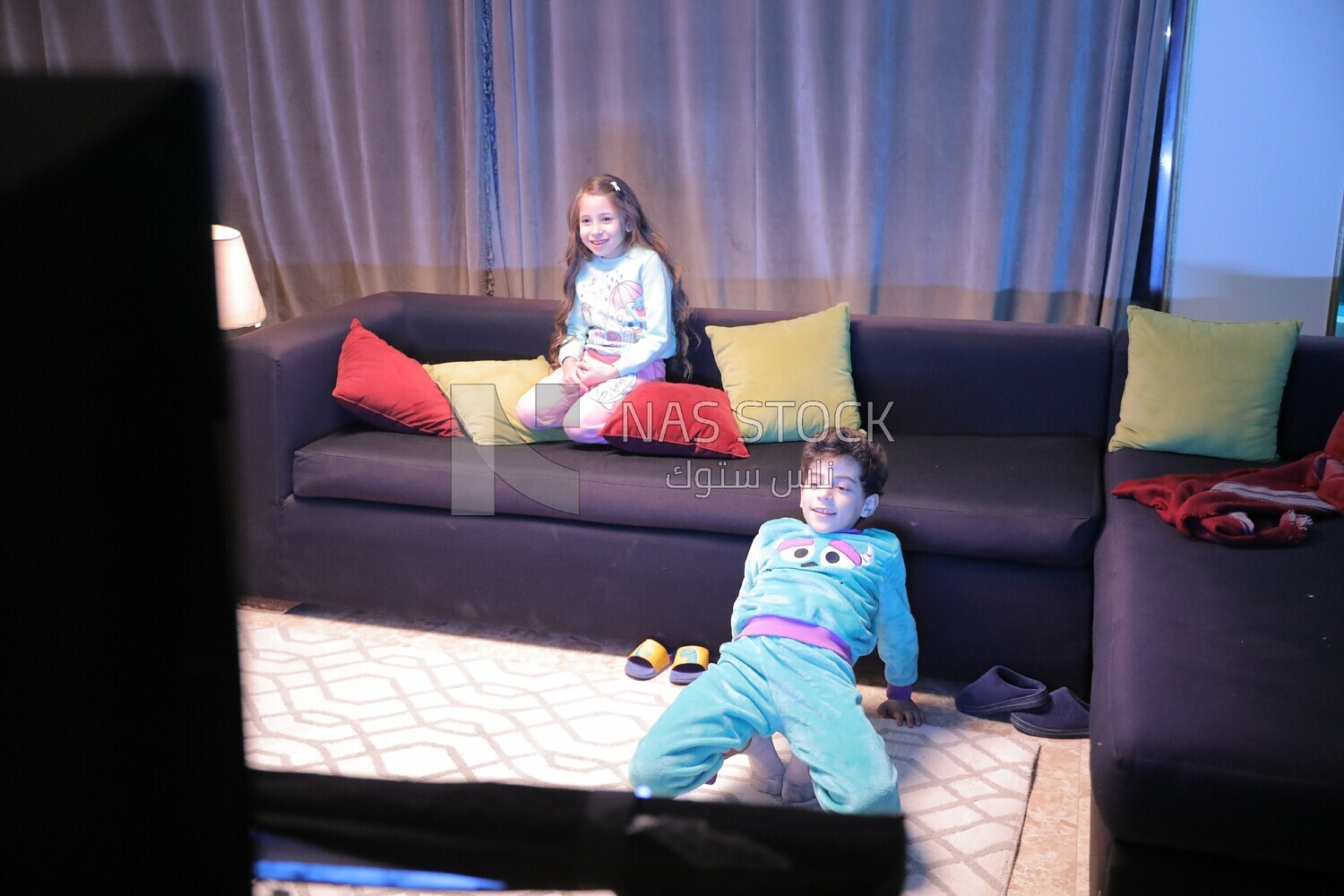 a brother and a sister playing in the living room