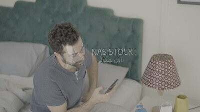 a man  sitting in bed waking up