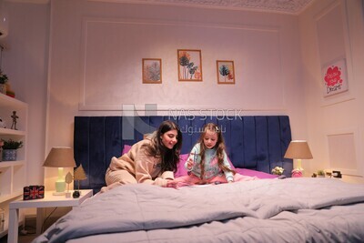 a mother with her daughter drawing together on the bed