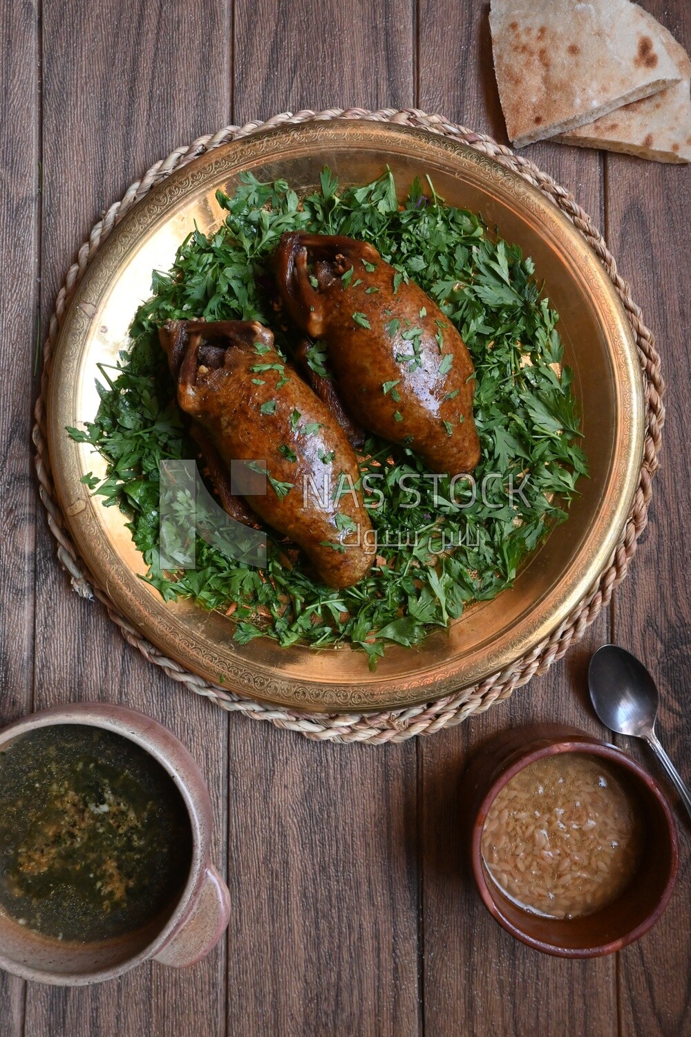 plate with stuffed pigeons beside soup and bread