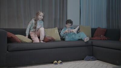a brother and a sister playing in the living room