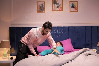 اب يضع ابنه على السرير