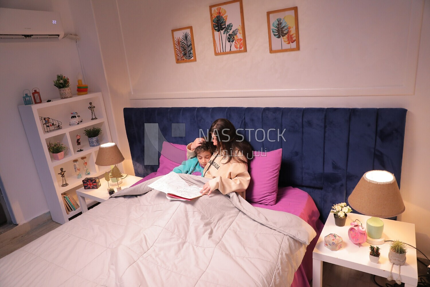 a woman reading a story to her son in bed