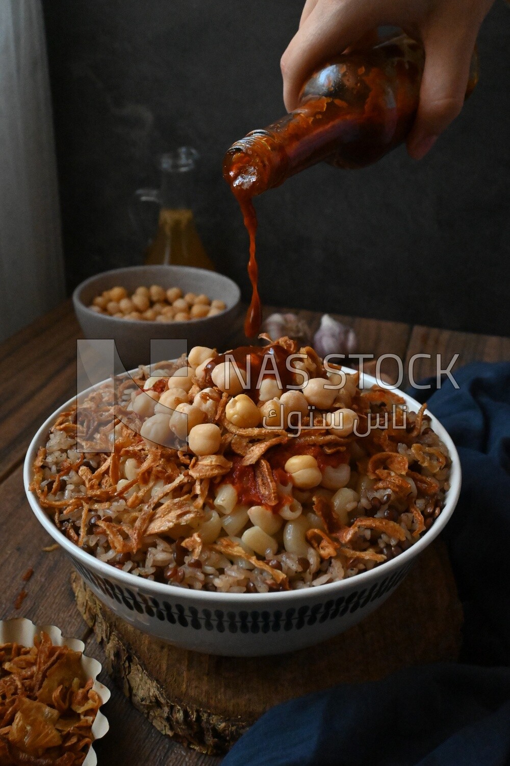 Hand puts spices on the koshary