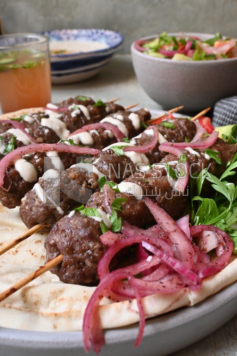 Dish with grilled kofta with tahini sauce on it