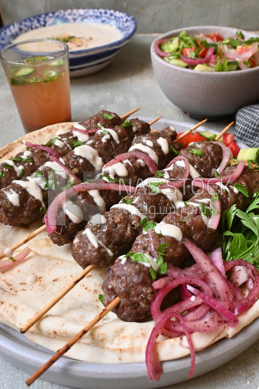Dish with grilled kofta with tahini sauce on it