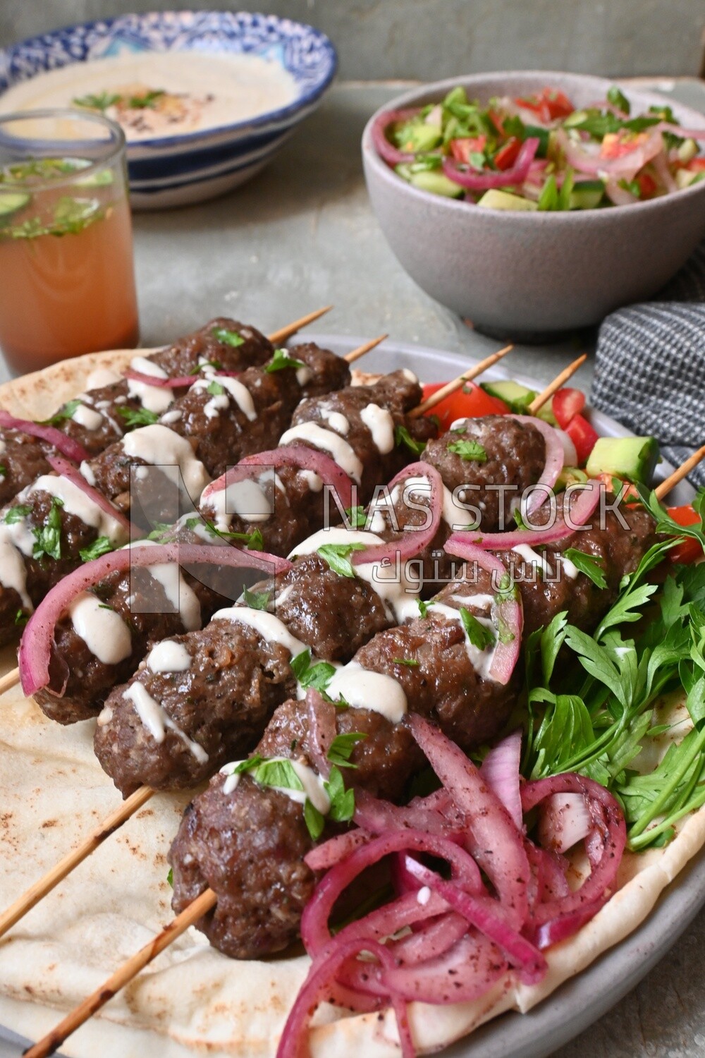 Dish with grilled kofta with tahini sauce on it