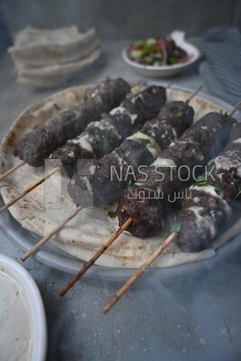 Dish with grilled kofta with tahini sauce on it
