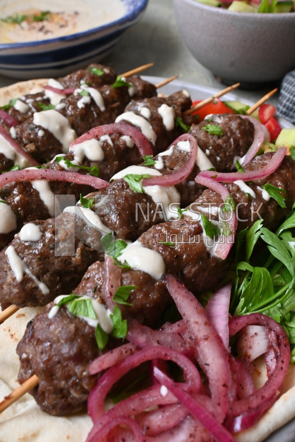 Dish with grilled kofta with tahini sauce on it