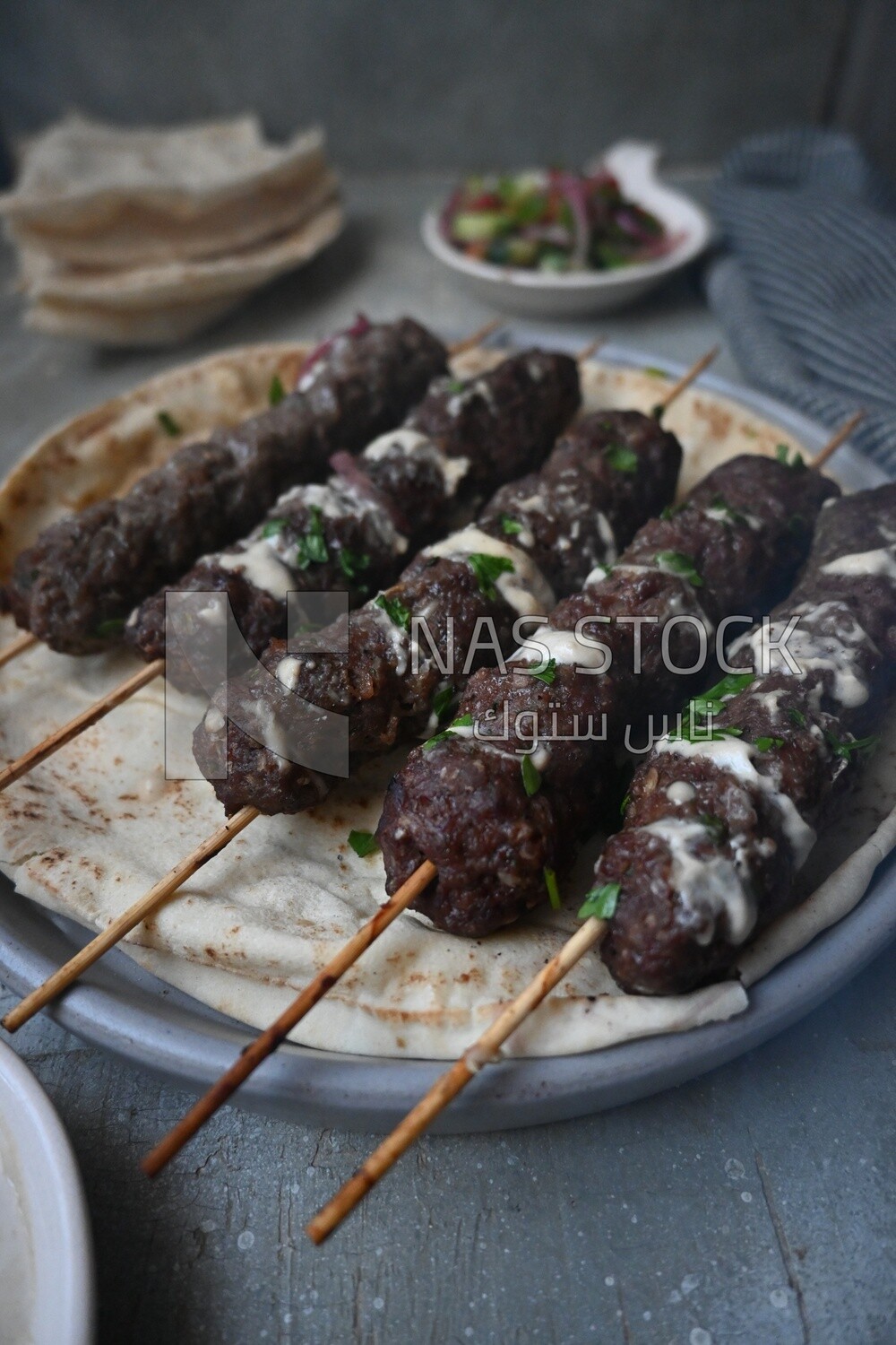 Dish with grilled kofta with tahini sauce on it
