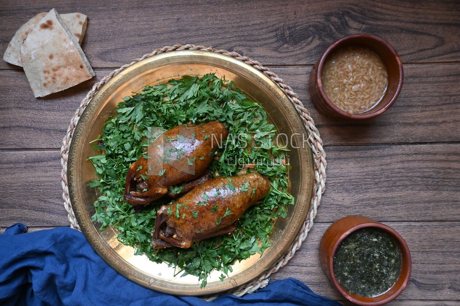 plate with stuffed pigeons beside soup and bread