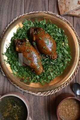 plate with stuffed pigeons beside soup and bread