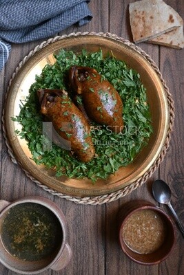 plate with stuffed pigeons beside soup and bread