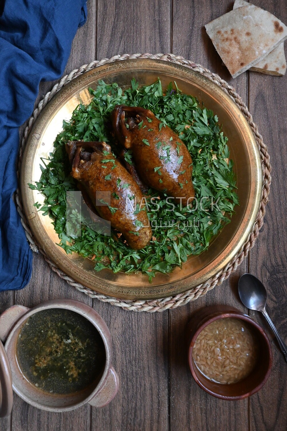 plate with stuffed pigeons beside soup and bread