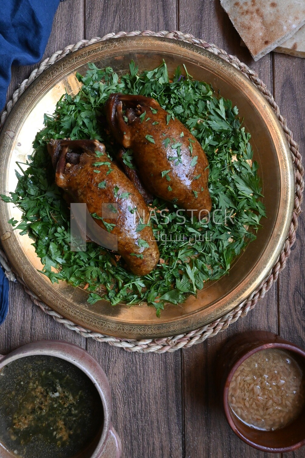 plate with stuffed pigeons beside soup and bread