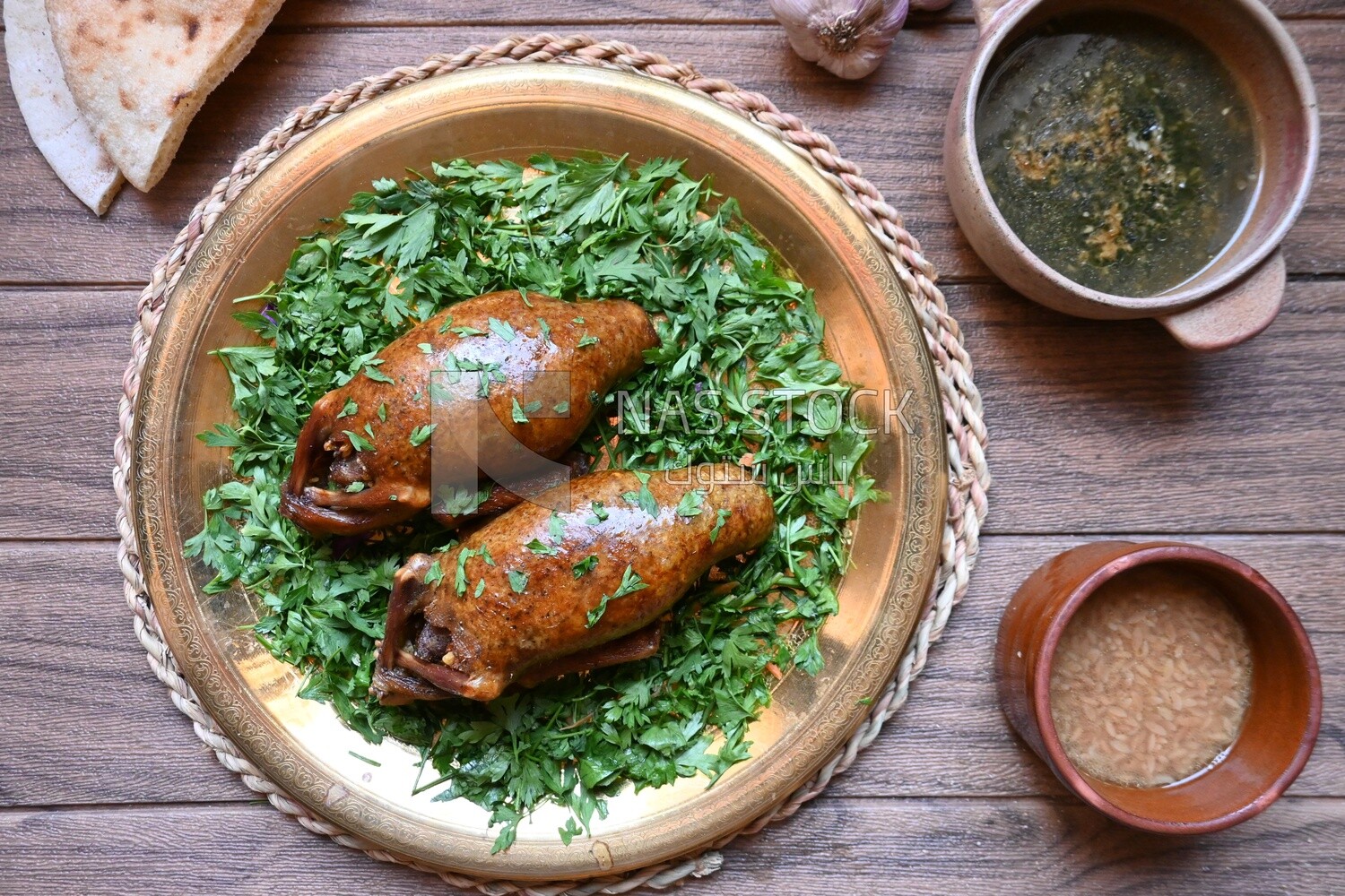 plate with stuffed pigeons beside soup and bread