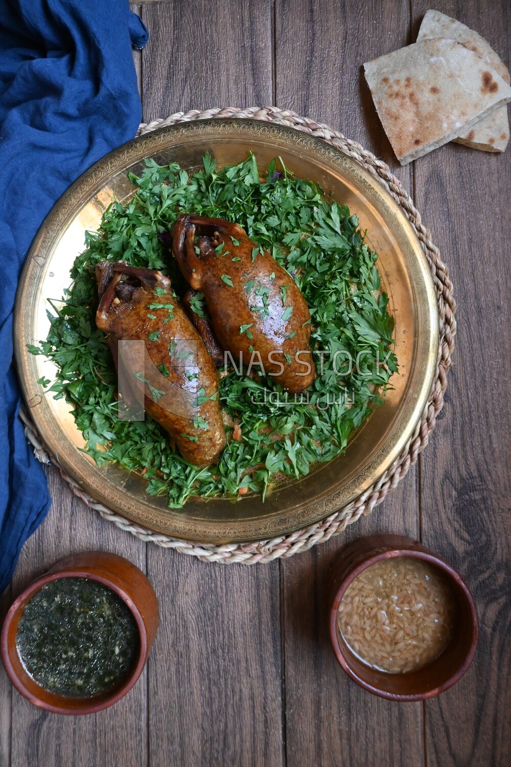 plate with stuffed pigeons beside soup and bread.