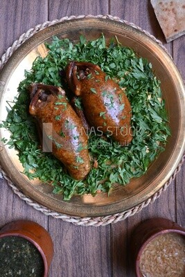 plate with stuffed pigeons beside soup and bread