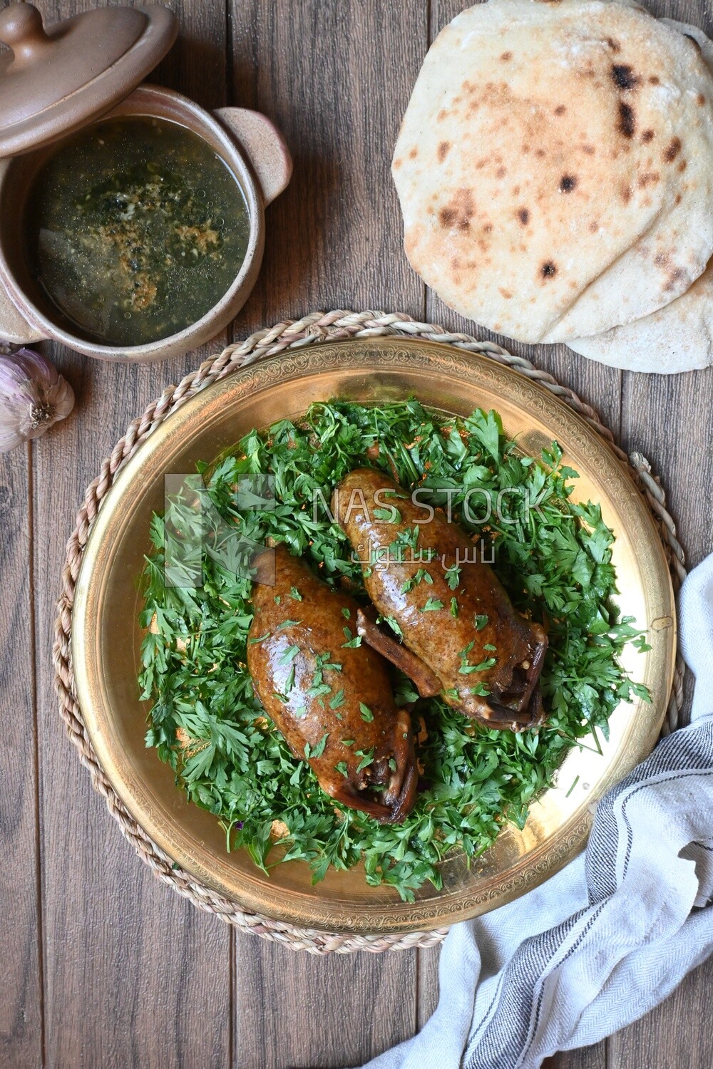 plate with stuffed pigeons beside soup and bread
