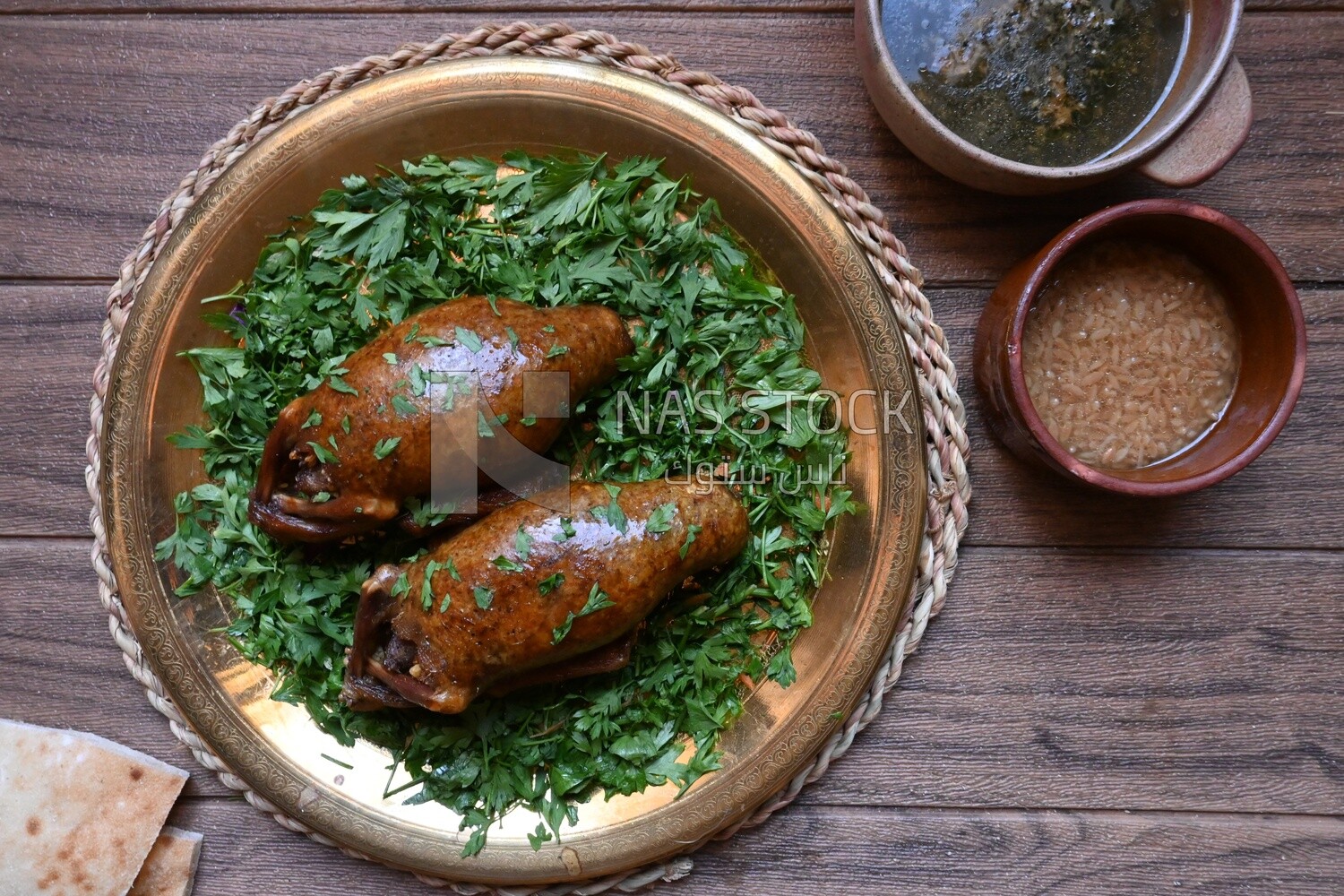 plate with stuffed pigeons beside soup and bread