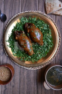 plate with stuffed pigeons beside soup and bread