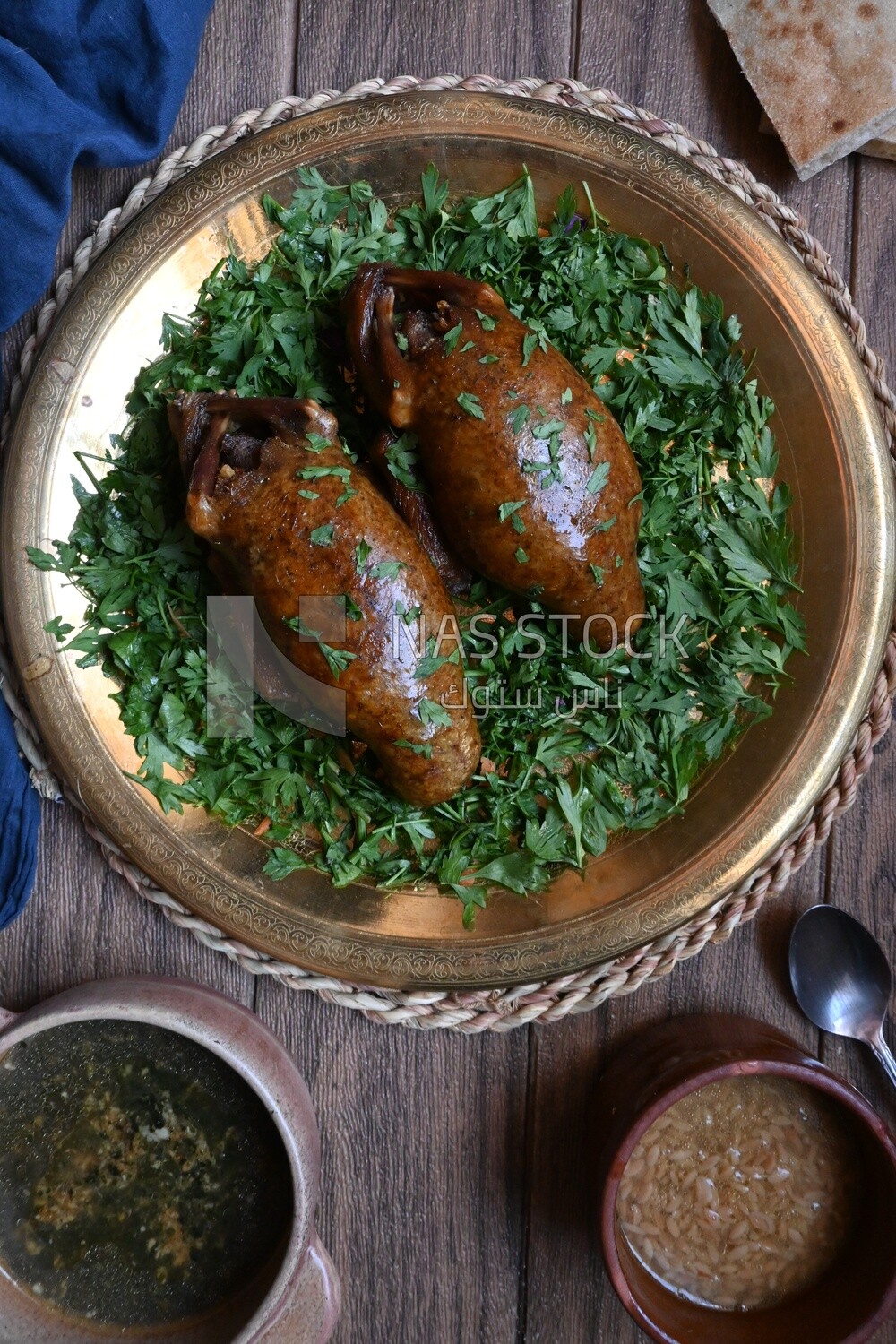 plate with stuffed pigeons beside soup and bread
