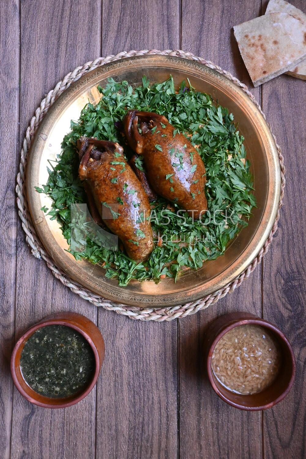 plate with stuffed pigeons beside soup and bread