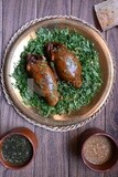 plate with stuffed pigeons beside soup and bread