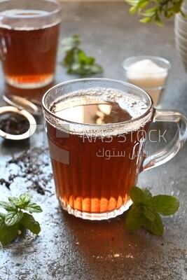 Two cups of tea beside a sugar