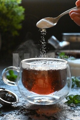 Spoon of sugar dropped on a cup of tea