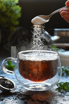 Spoon of sugar dropped on a cup of tea