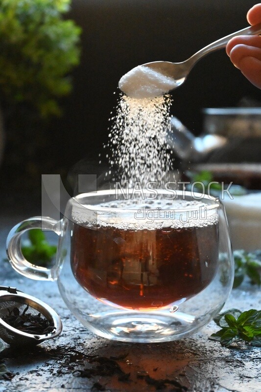 Spoon of sugar dropped on a cup of tea